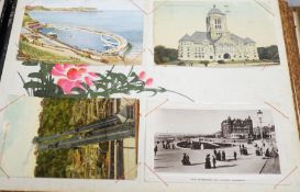 An early 20th century inlaid postcard album and contents