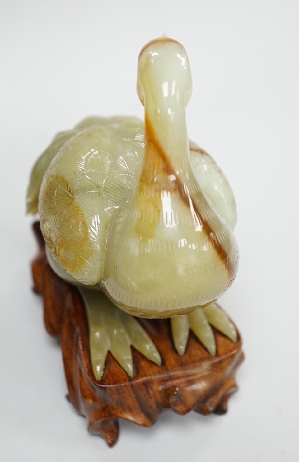 A Chinese green and russet jade figure of a crane, 11.5cm long, wood stand Provenance - the former - Image 3 of 3