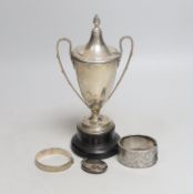 A George V silver two handled trophy cup, 19.6cm, on stand, two silver hinged bangles and a white
