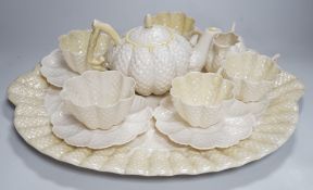 A Belleek porcelain teaset comprising tray, teapot, milk jug, sugar bowl, four cups and four