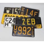 Eight New York and other car number plates, with badges attached