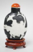 A Chinese porcelain white on black ground silhouette snuff bottle, 5.6 cm excluding stopper and wood