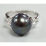 A modern 750 white metal, single stone Tahitian pearl and two stone trillion cut diamond set ring,