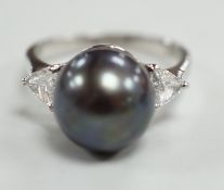 A modern 750 white metal, single stone Tahitian pearl and two stone trillion cut diamond set ring,