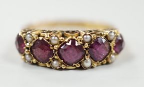 A late Victorian 15ct gold and graduated five stone garnet set half hoop ring, with split pearl
