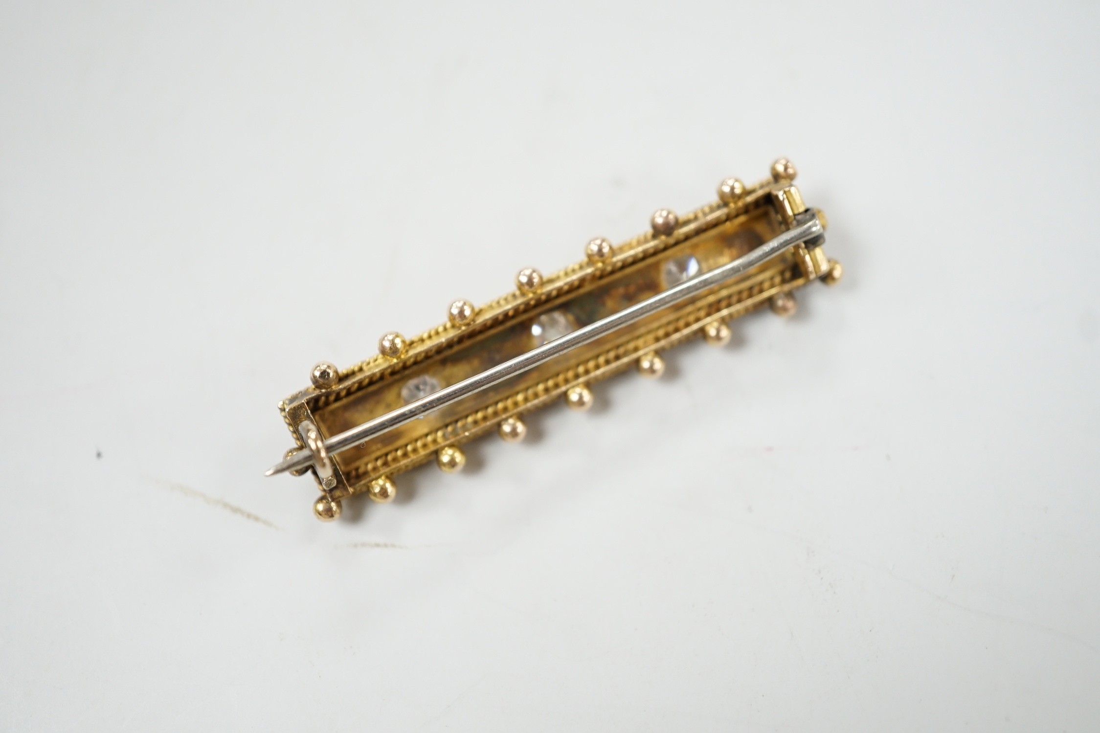 An early 20th century yellow metal, three stone diamond and four stone split pearl set bar brooch, - Image 3 of 3