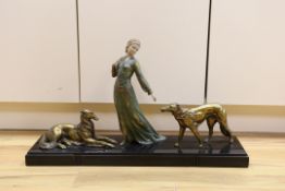 A French Art Deco female spelter figure and two bronzed spelter dogs on black marble base, signed