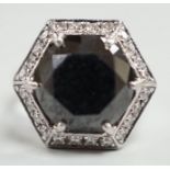 A modern 750 white metal and hexagonal cut black diamond set dress ring, with diamond chip set