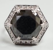 A modern 750 white metal and hexagonal cut black diamond set dress ring, with diamond chip set