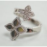 A modern stylish Italian 18kt white metal and four stone diamond set open flower head ring, maker RC