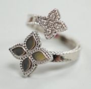 A modern stylish Italian 18kt white metal and four stone diamond set open flower head ring, maker RC