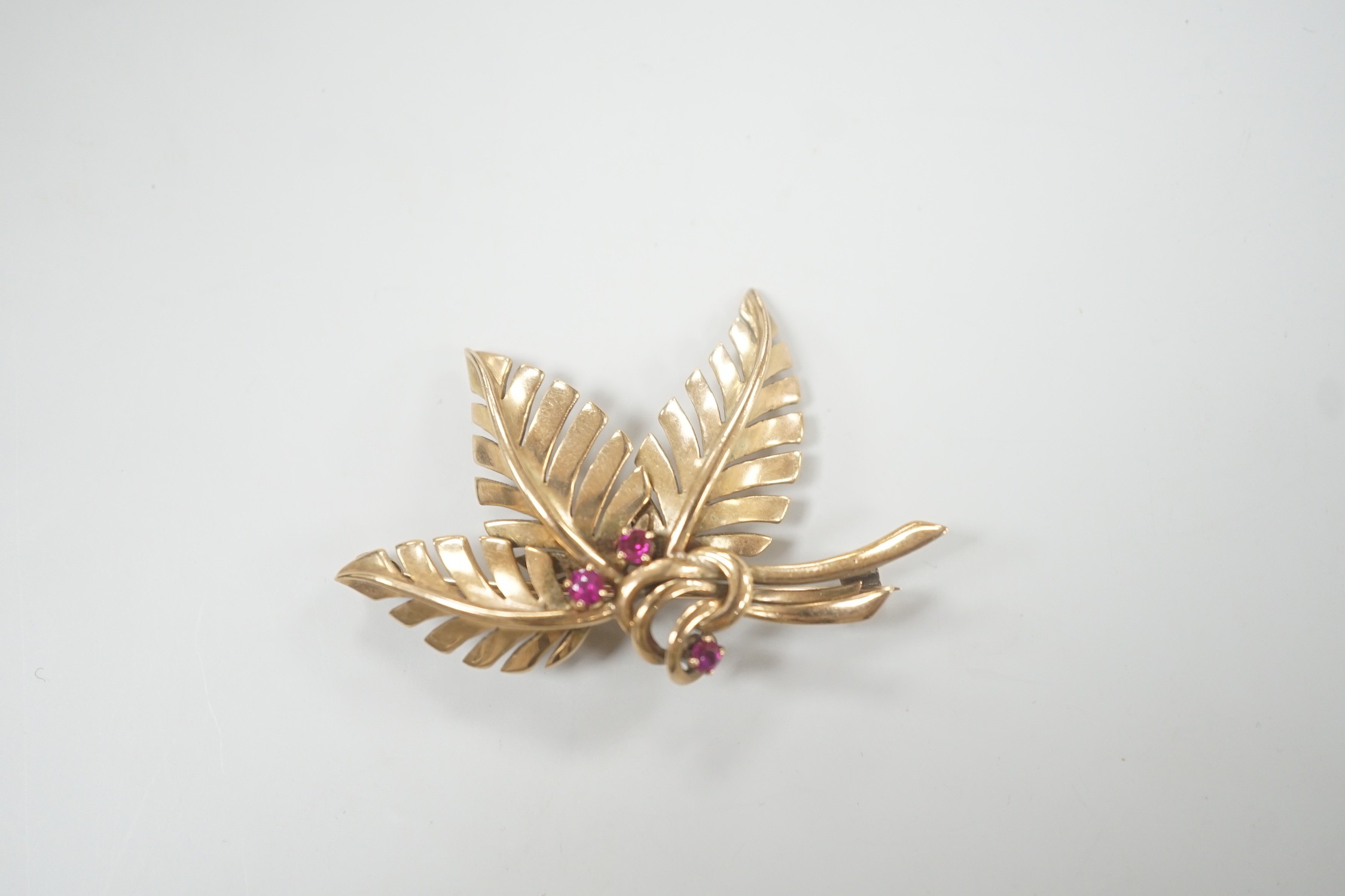 A yellow metal and three stone ruby set foliate brooch, 45mm, gross weight 6.8 grams. - Image 3 of 4