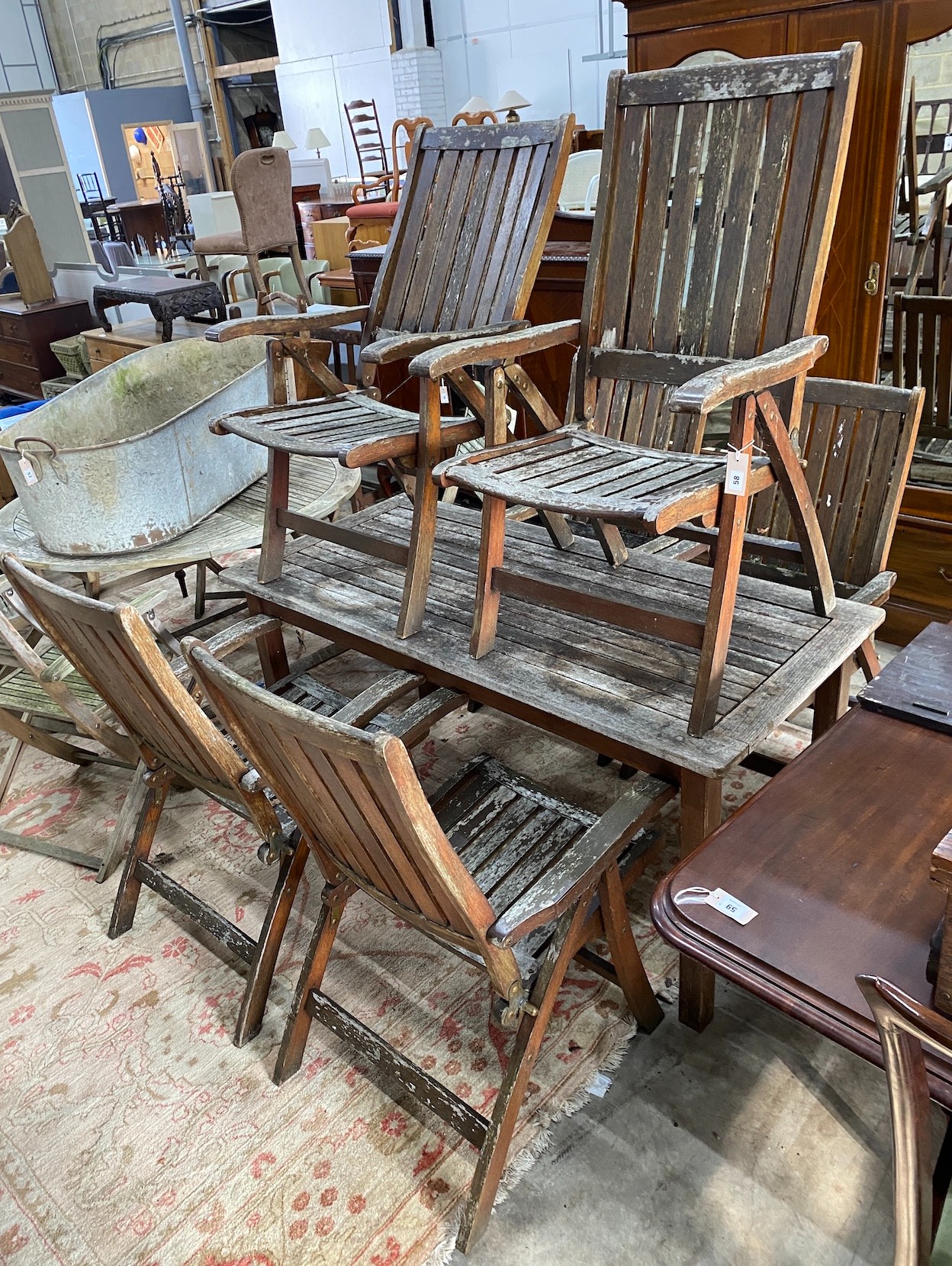 A rectangular weathered teak garden table, length 151cm, depth 70cm, height 73cm and six folding