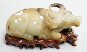 A large Chinese grey and black jade figure of a recumbent buffalo, 17cm long, wood stand