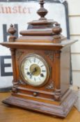 A 19th century German walnut mantel clock with key and pendulum, 40cm tall