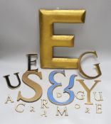 A collection of brass and enamelled lettering of varying sizes and fonts