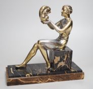 An Art Deco spelter gilded and silvered seated lady holding a squirrel, on marble and onyx mount,