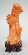 A Chinese coral figure of Shou Lao, 20th century, 7.4 cm high, 73g, wood stand Provenance - the