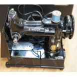 A cased portable Singer Featherweight 222K sewing machine with accessories