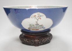 A 19th century Chinese famille verte powder blue bowl, 26cm diameter, wood stand