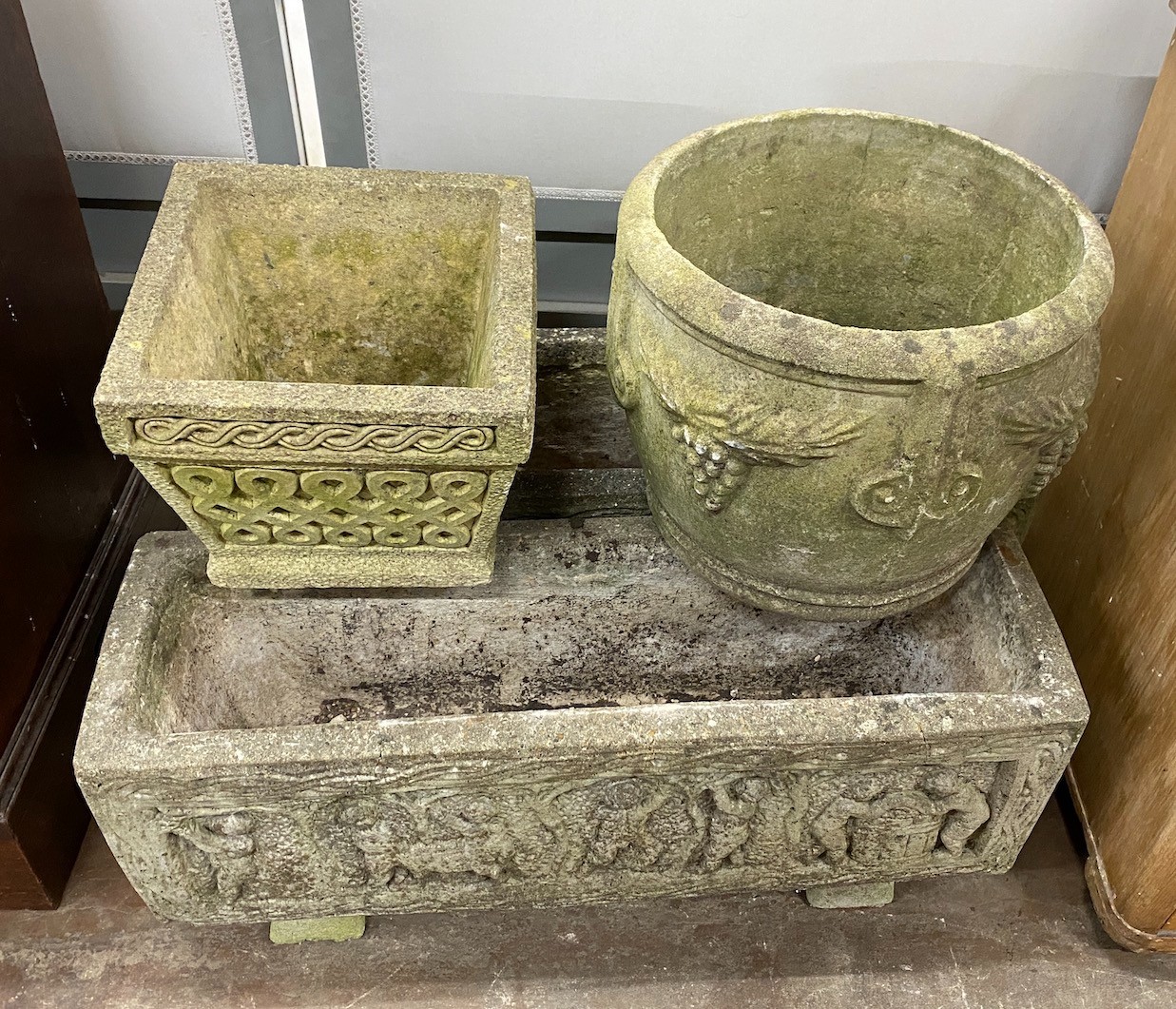 A pair of rectangular reconstituted stone garden planters length 80cm, a circular planter and