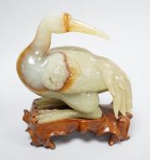 A Chinese green and russet jade figure of a crane, 11.5cm long, wood stand Provenance - the former