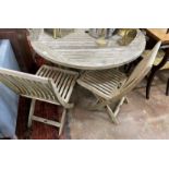 A Gloster weathered teak circular garden table, diameter 130cm, height 70cm and four folding chairs