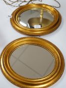 A small pair of oval gilt plaster framed wall mirrors, 34x30cm