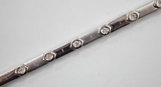 A modern 18k white metal and diamond chip set line bracelet, 15cm, gross weight 10.4 grams.