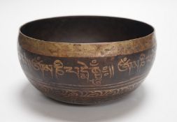 A bronze Nepalese temple bowl decorated with script, 18cm diameter