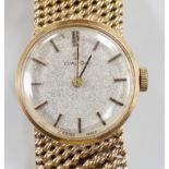 A lady's modern 9ct gold Omega manual wind wrist watch, on a 9ct gold Omega bracelet, case