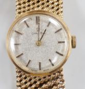 A lady's modern 9ct gold Omega manual wind wrist watch, on a 9ct gold Omega bracelet, case