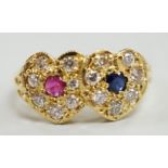 A modern 18ct gold, ruby, sapphire and diamond set twin heart cluster ring, size M, gross weight 4