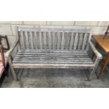 A weathered teak garden bench, length 153cm, depth 59cm, height 89cm