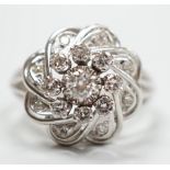 A French white metal (18ct poincon mark) and diamond cluster set dress ring, size L/M, gross