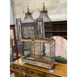 An early 20th century continental beech framed wire work bird cage of twin turret design with turned