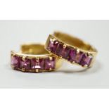 A modern pair of Italian 750 yellow metal and four stone square cut garnet set hoop earrings,