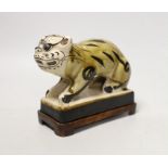 A Chinese Cizhou style pottery ‘tiger’ incense stick holder on wood stand, 13cm tall