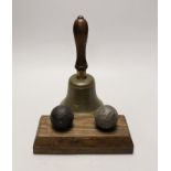 Two cannon balls, together with a brass hand bell marked A.R.P