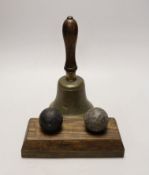 Two cannon balls, together with a brass hand bell marked A.R.P