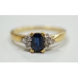 A modern 18ct gold and single stone sapphire set ring, with six stone diamond set shoulders, size R,