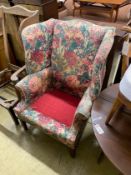 A floral upholstered Georgian style wing armchair (in need of recovering), width 79cm, depth 55cm,