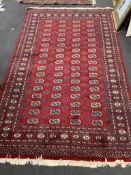 A Bokhara red ground rug, 246 x 152cm