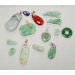 Twelve assorted carved jadeite items including five pendants, largest 40mm, a 14k mounted