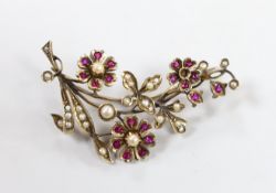 An early to mid 20th century, yellow metal, ruby and seed pearl cluster set floral spray brooch,