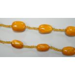 A single strand graduated fifteen amber bead necklace, with multiple amber? spacers, 84cm, gross