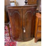 A George III oak bow front hanging corner cupboard, width 64cm, depth 40cm, height 100cm