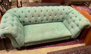 A Victorian double drop arm Chesterfield settee upholstered in a deep buttoned green fabric,
