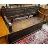 An 18th century style brass studded carved oak box seat settle, length 136cm, depth 40cm, height