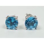 A modern pair of white metal (stamped 18) and single stone blue topaz set ear studs, 7mm, gross